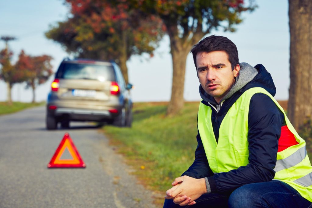 man sitting beside the road