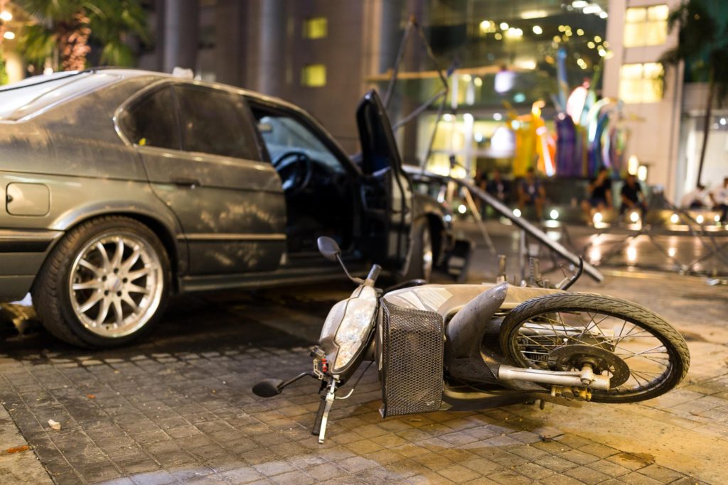 motorcycle fell down beside the car